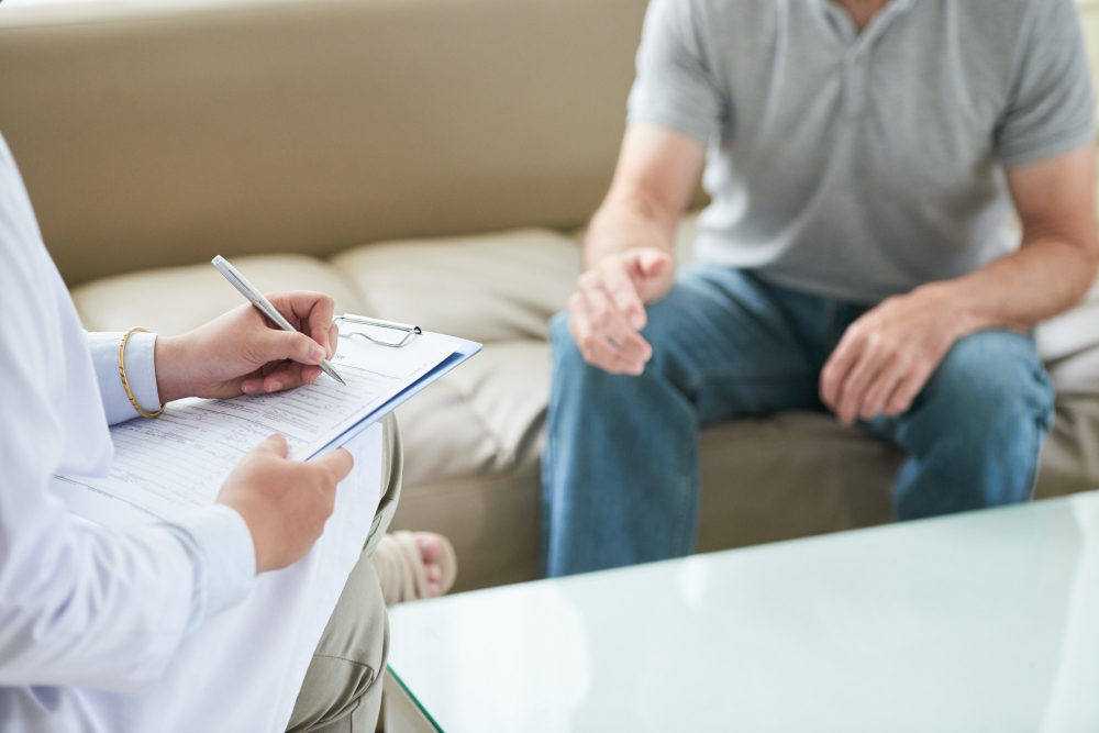 unrecognizable-female-doctor-talking-patient-writing-during-house-call